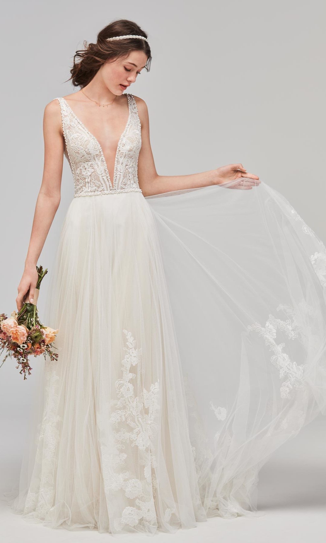 Braut mit Schleppe und Brautstrauß in der Hand